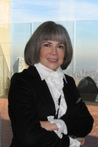 Anne Rice standing in front of city window view